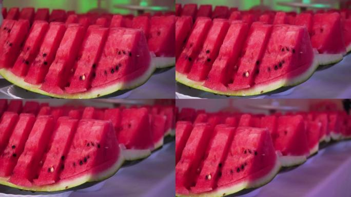 红色的夏季水果西瓜在节日的餐桌上。节日餐桌的装饰，甜品的西瓜片