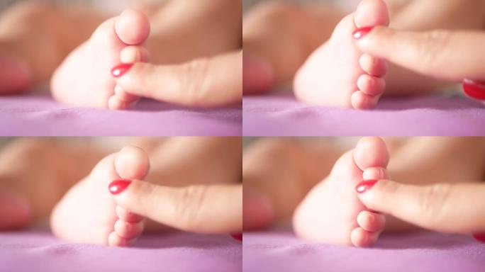 妈妈抚摸着新生婴儿的脚。妈妈抱着婴儿脚的特写镜头。母亲抚摸着刚出生的婴儿的手指。母亲轻轻地抚摸着刚出