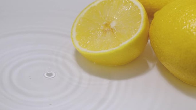掉进水里的柠檬，发散的圆圈。天然柑橘类水果柠檬。维生素，健康饮食理念
