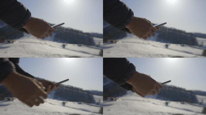 手在冬山用电话，特写。在新型冠状病毒肺炎大流行的同时，在自然界中独自一人。精神卫生和生活平衡。