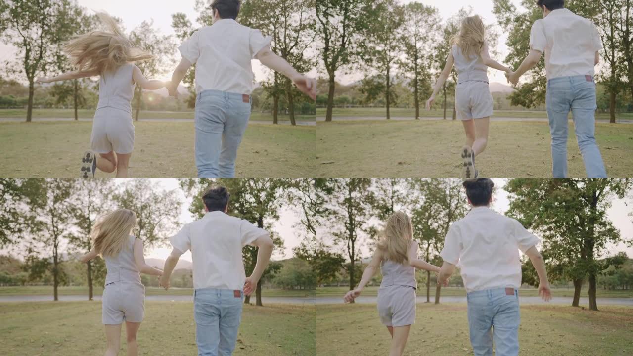 年轻的成年夫妇手牵着手穿过公园花园，走出城市，难忘的时刻