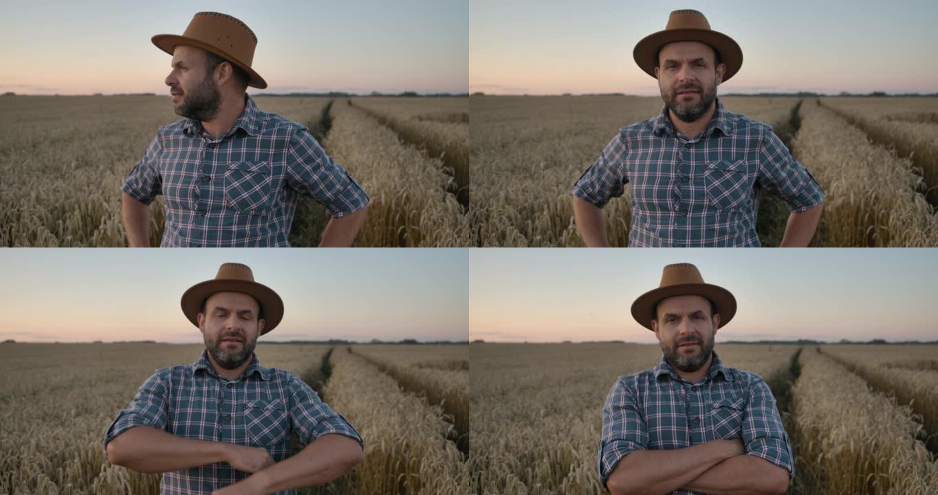 肖像高加索农民男子穿着帽子的格子衬衫看着相机。农田日落景观农业。肖像农民留着帽子的男人站在麦田里。农