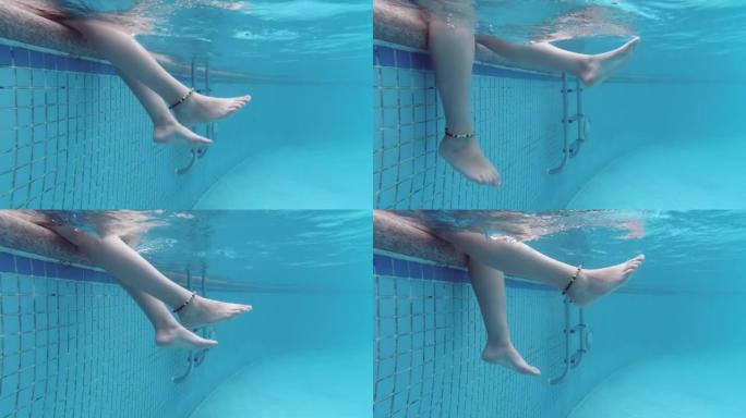 温柔女人用脚泼水的水下视图。炎热夏日的快乐。游泳池和阳光。