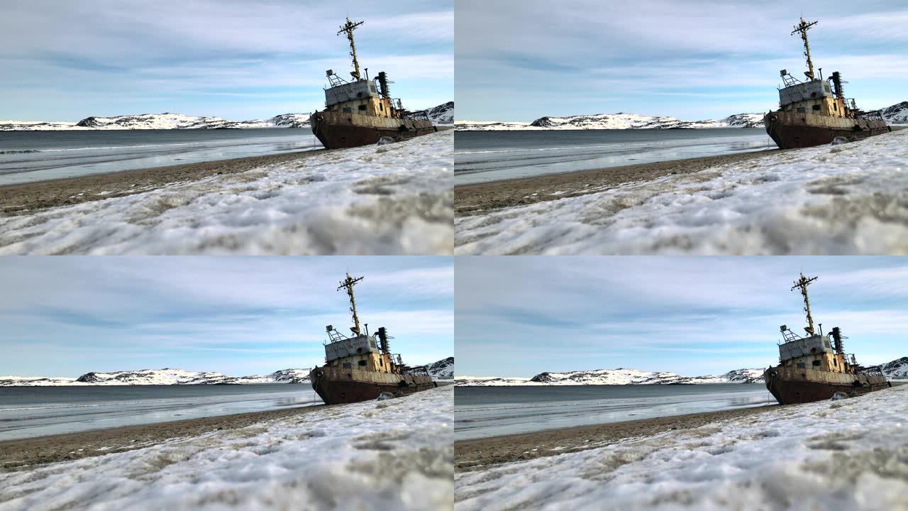 在下雪的冬季，在海边淹死的旧失事渔船的空中俯视图。镜头。俄罗斯特里伯卡雪沙海岸附近冷水中被毁船的鸟瞰