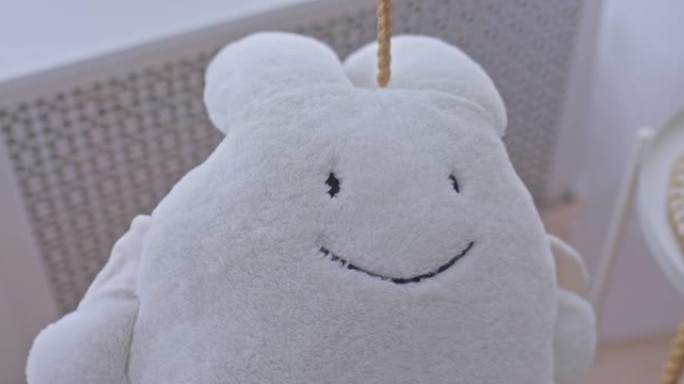 毛绒白色野兔坐在灯光室的秋千上，特写镜头。室内毛绒玩具，玩具有趣的野兔。4k，普洛雷斯