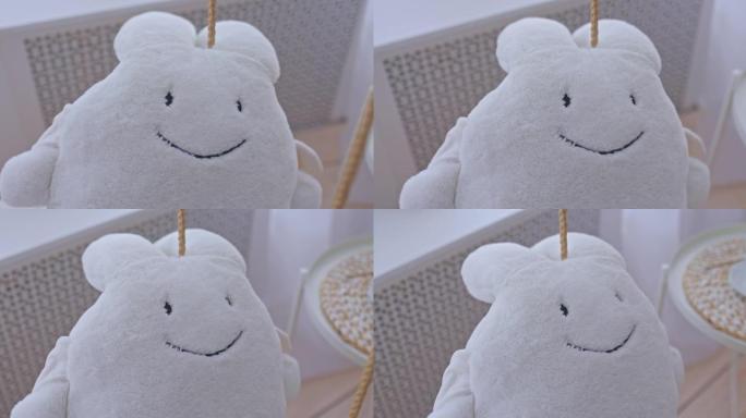 毛绒白色野兔坐在灯光室的秋千上，特写镜头。室内毛绒玩具，玩具有趣的野兔。4k，普洛雷斯