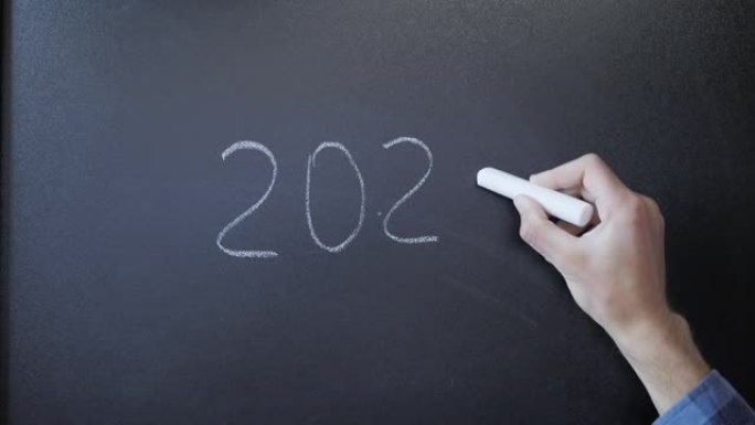 黑板上有数字2021和划掉。黑板上的手写2021