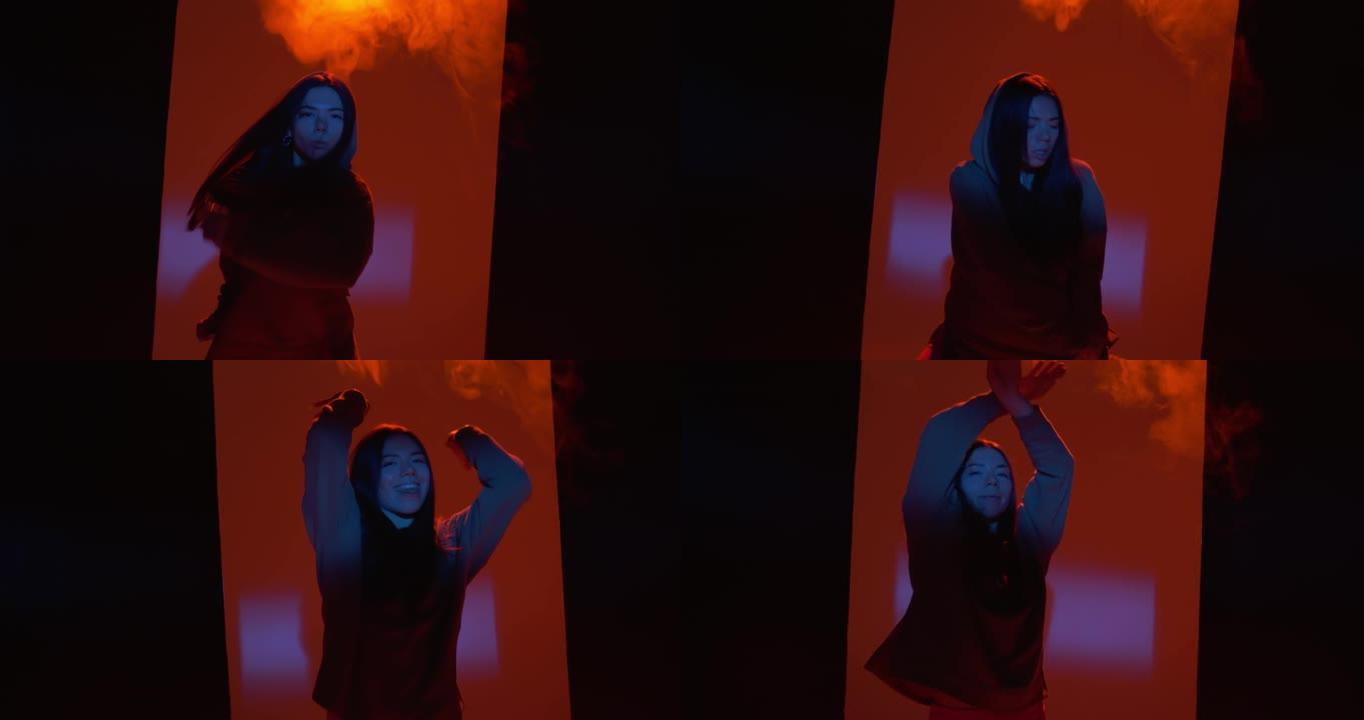 跳舞的年轻女孩在工作室里用烟雾在五颜六色的灯光下表演自由式舞蹈。现代生活方式、说唱和嘻哈
