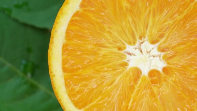橙色水果与切片特写，顶视图旋转水果，甜橙色水果与绿色叶子在花园里。
