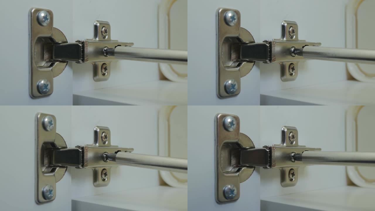 主人拧动厨房橱柜门铰链的调节螺钉。厨柜门的安装和调整。特写。4K