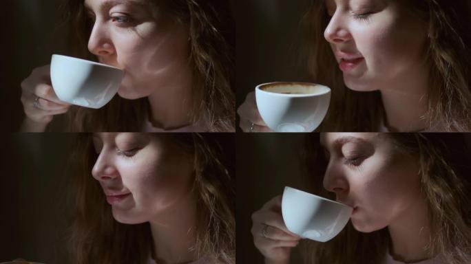 女孩从白杯中愉快地喝咖啡的特写镜头。