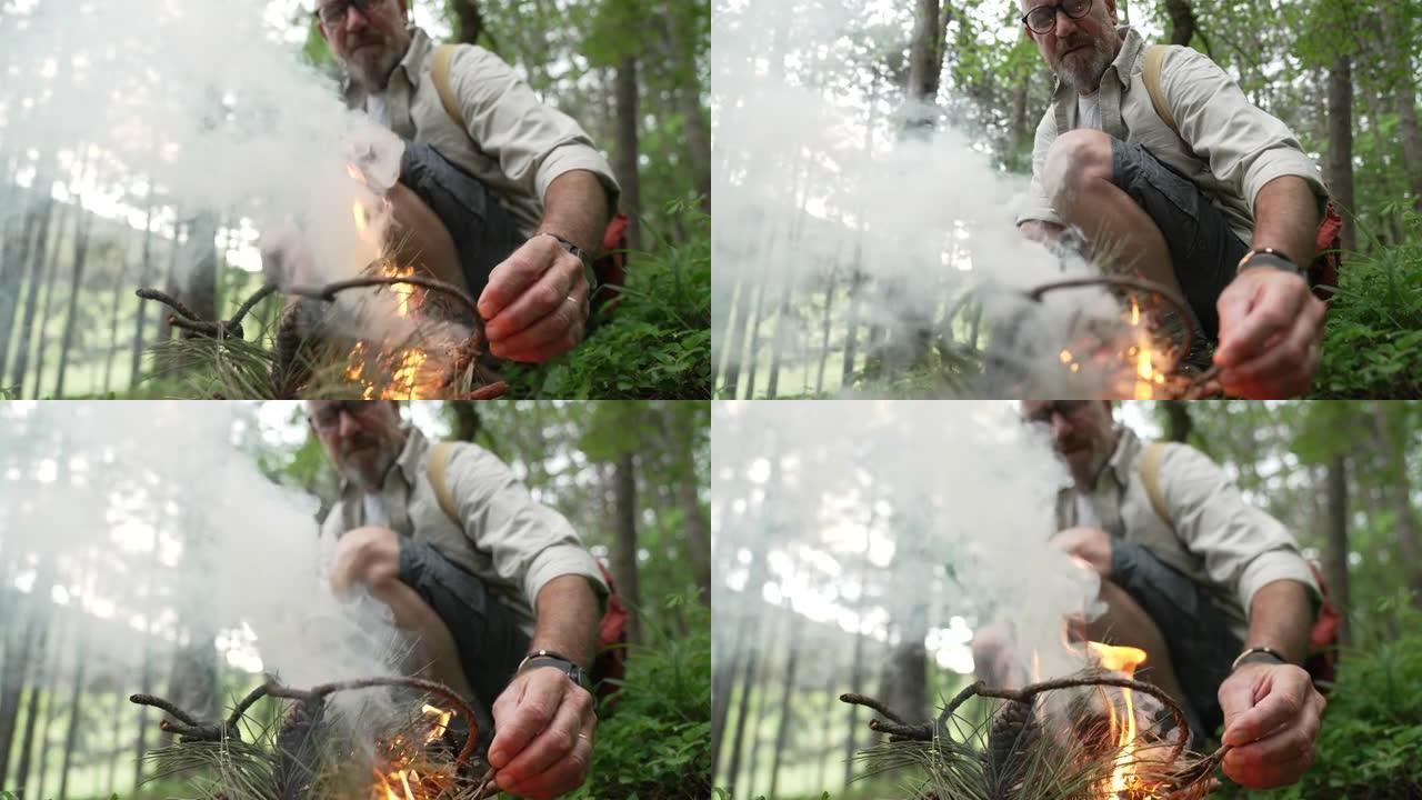 男人在树林里点燃篝火