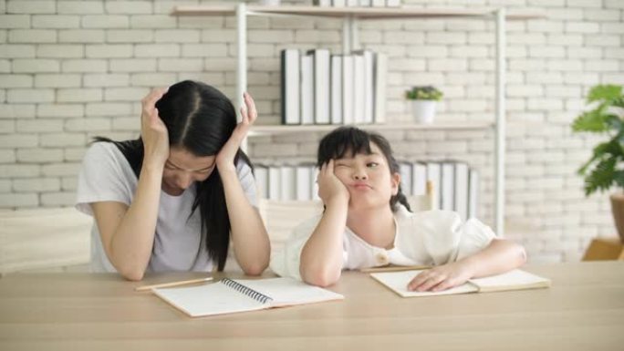沮丧的母亲在做作业时对女儿感到压力