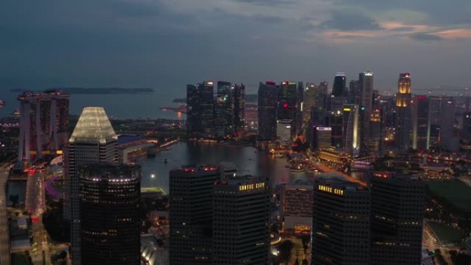 日落夜照明飞行在著名的新加坡市中心滨海湾空中全景4k