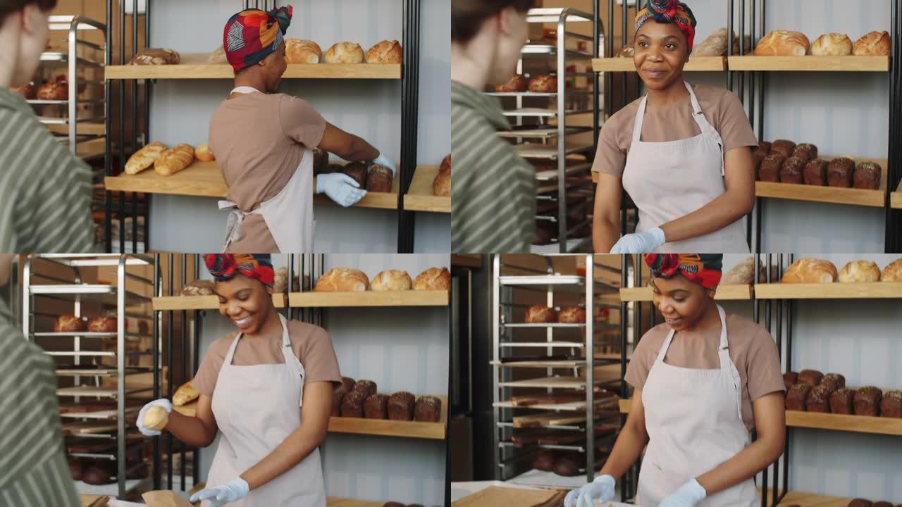 美丽的黑人妇女在面包店卖新鲜面包