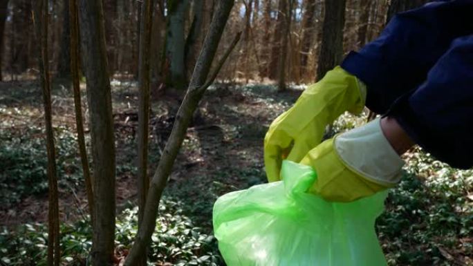 森林树枝上的医用防护口罩。冠状病毒的后果 (新型冠状病毒肺炎)。生态污染，医疗垃圾概念。志愿者清理公