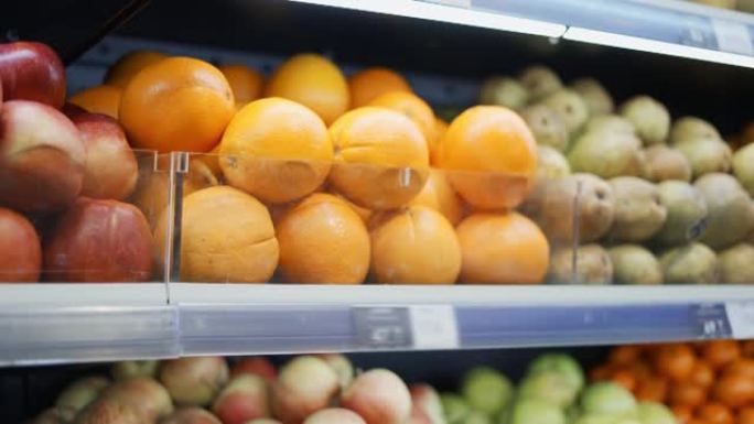无法识别的非洲裔美国男子站在超市里选择橘子
