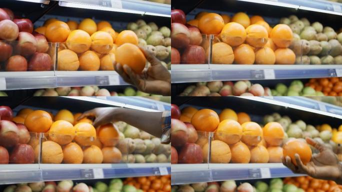 无法识别的非洲裔美国男子站在超市里选择橘子