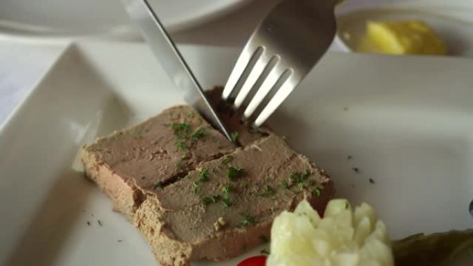法国餐厅的刀叉切鹅肝开胃菜，咸菜和土豆泥