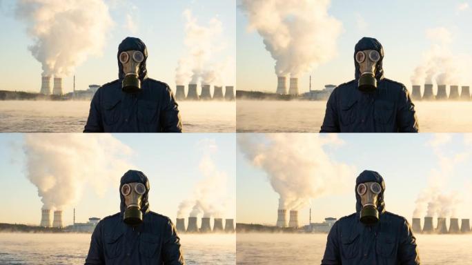核电站的延时发电厂将化学物质释放到大气中。一个人戴着防毒面具站着。储液罐蒸发了。全球变暖和辐射