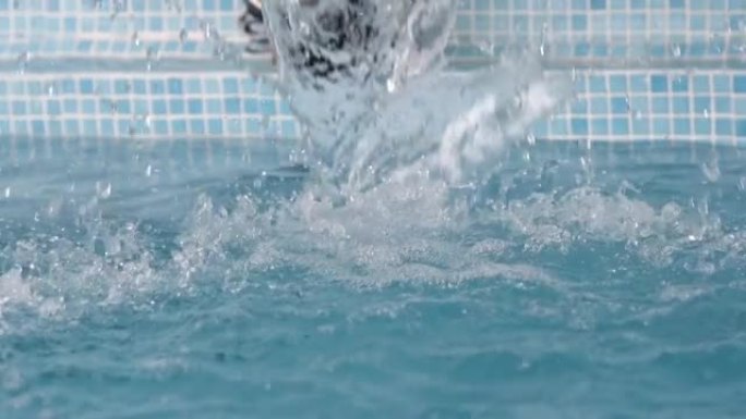 水溅入游泳池的慢动作，水滴从水面喷出