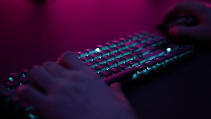 玩家老兄在蓝色照明游戏键盘上玩电脑游戏。