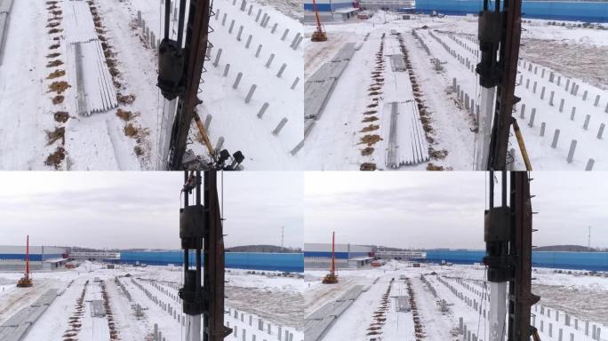 冬季施工现场工作的桩孔机的近距离空中无人机视图