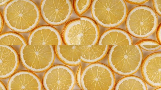 橙色背景上的新鲜橙片慢动作。橙色水果图案。健康食品背景。微距拍摄