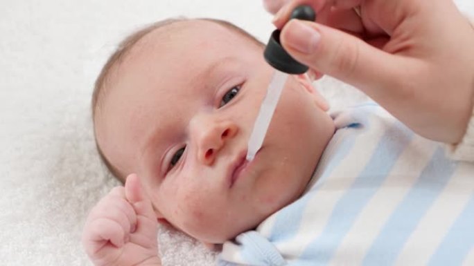 用滴管或注射器给新生男婴接种疫苗的特写镜头。婴儿和新生儿接种疫苗并给予维生素的概念。有小孩的有爱心的
