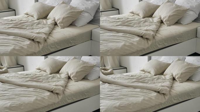 舒适的床，配有柔软的枕毯和皱巴巴的亚麻布