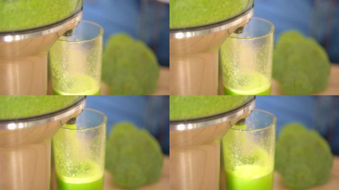 榨汁机制作绿色西兰花蔬菜汁。榨汁机和绿色果汁杯的特写