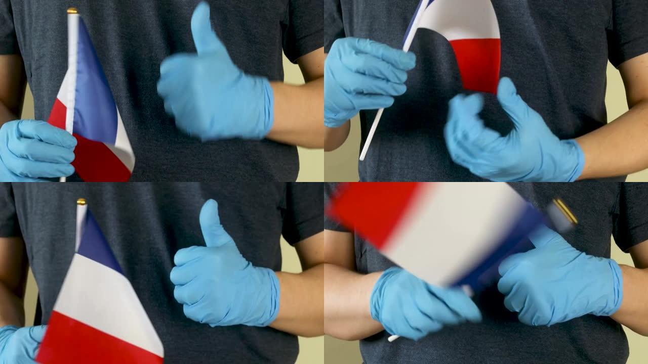 一个人手中的法国国旗。戴着医用手套挥舞法国国旗。