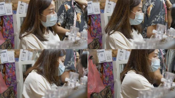 戴着口罩的亚洲夫妇在新型冠状病毒肺炎covid电晕病毒情况下购物一些布