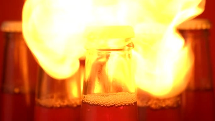 火焰爆发并包围了五个玻璃瓶液体。对饮料开火。黑暗中闪烁
