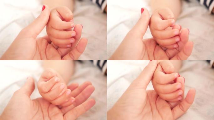 孩子在梦中握着母亲的手。妈妈抱着婴儿手指的特写镜头。在母亲保护下的婴儿。母亲轻轻地抚摸着新生婴儿的小