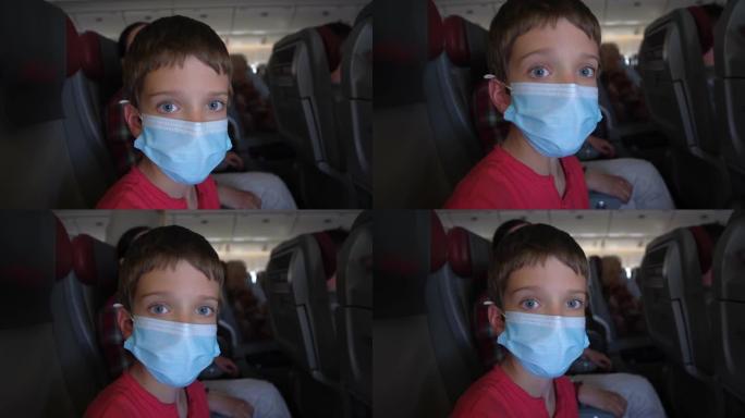 冠状病毒新型冠状病毒肺炎。旅行者旅游男孩戴着口罩坐飞机在里面看相机。病毒爆发检疫旅客旅行大流行概念。