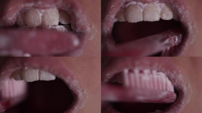 用粉红色牙刷和牙粉刷牙的人的极端特写视图。早晨卫生。张口和嘴唇的宏观视图。