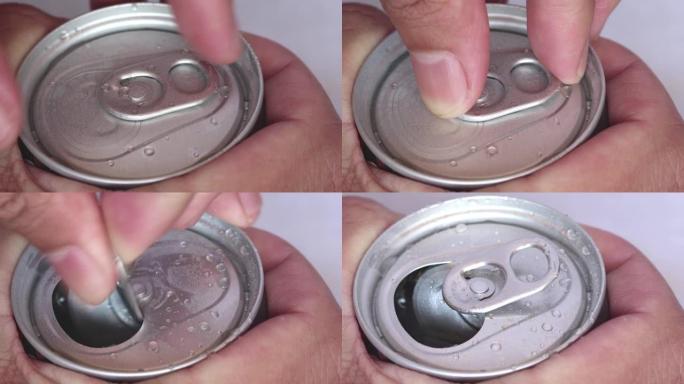特写镜头的手正在打开铝制的咖啡罐，里面有气体，焦点灵敏。湿铝罐上的水滴。