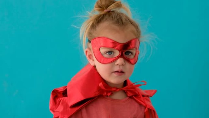 穿着红色超级英雄服装的有趣女孩，戴着面具波浪手