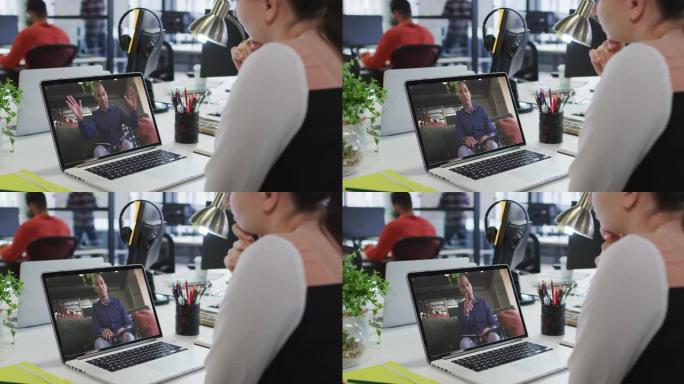 白人妇女在办公室的笔记本电脑上与男性办公室同事进行视频通话
