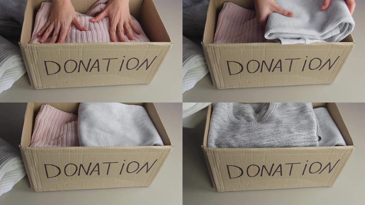 女人将保暖的衣服折叠到捐款箱中