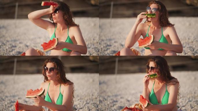 美丽的孕妇在海滩上享受一片西瓜