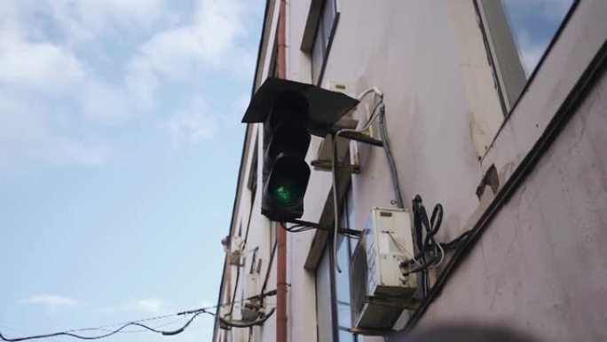 大楼墙上挂着红绿灯，旁边挂着空调。拍摄城市环境的物体