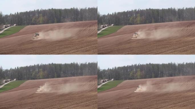 由于干燥的田野，拖拉机在田野上流失了灰尘