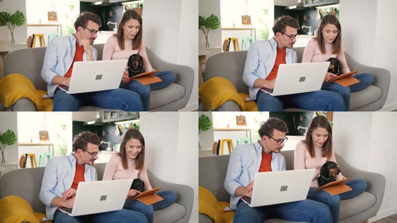 年轻的高加索夫妇在家庭办公室与笔记本电脑和数字平板电脑一起工作