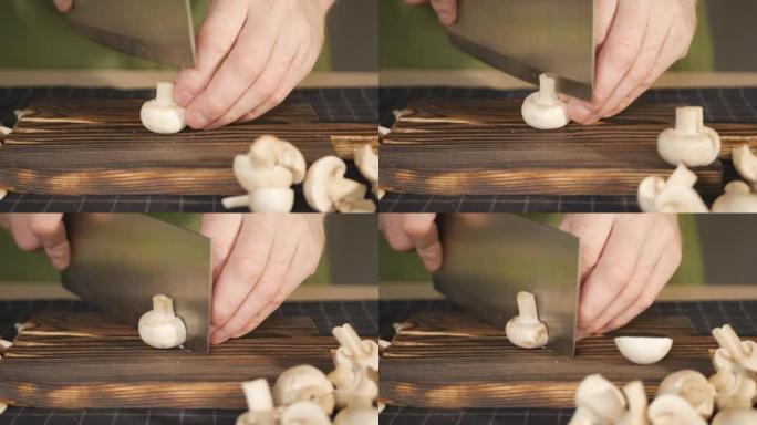 厨师用大刀将蘑菇切成两部分，放在一边。健康饮食的生态产品。