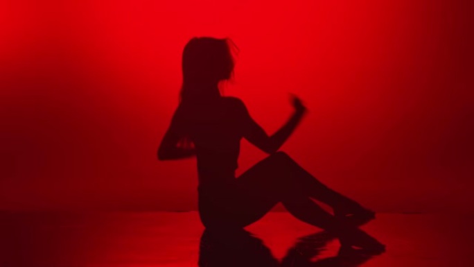 热辣女人剪影表演完美的伸展舞蹈在深红色工作室。4k Dragon RED摄像机