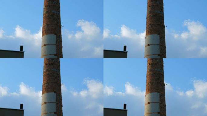 背景蓝天上的旧砖烟道管