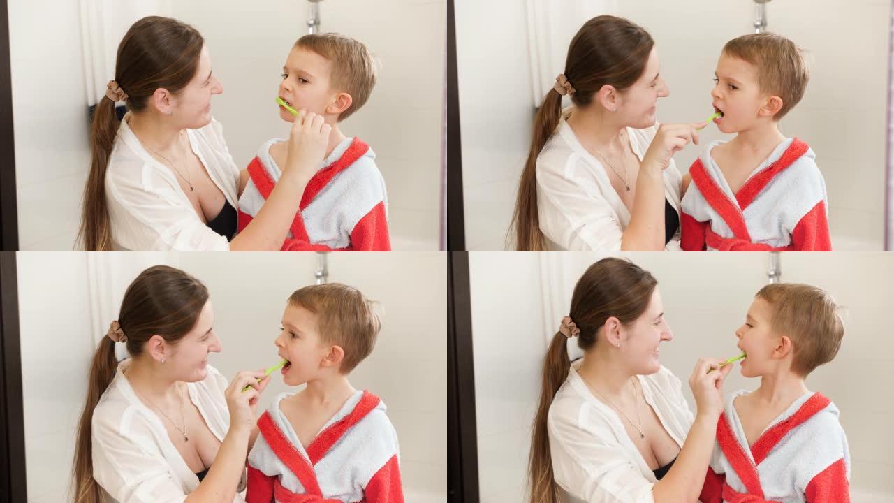 微笑的母亲在浴室里给小儿子刷牙的肖像。家庭儿童卫生和保健概念。在家关心父母和孩子。
