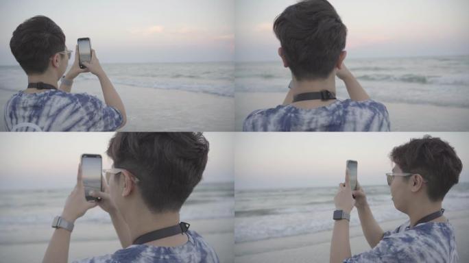 亚洲女性拿着智能手机拍摄海景。